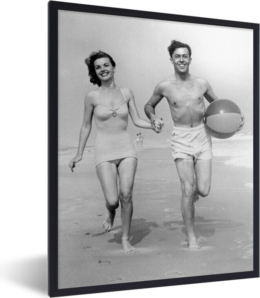 MuchoWow MuchoWow Gerahmtes Poster Junges Paar beim Laufen am Strand in den 1950er Jahren 60x80 cm - Poster mit zchwarzem Bilderrahmen - Premiu...