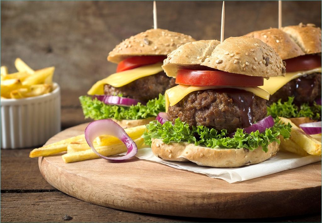 Wallario Fototapete Vliestapete, seidenmatte Oberfläche, einfache Verarbeitung, Größe 200 x 140 cm, Motiv Saftige Burger auf Holzbrett