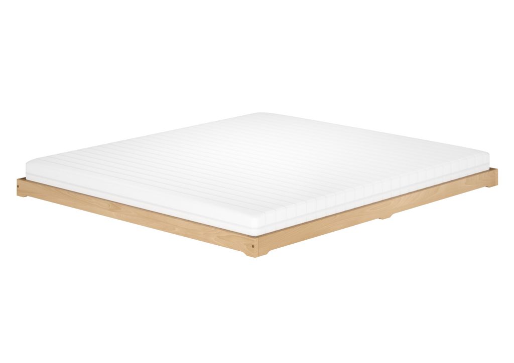 A white mattress on a low wooden bed frame against a white background.