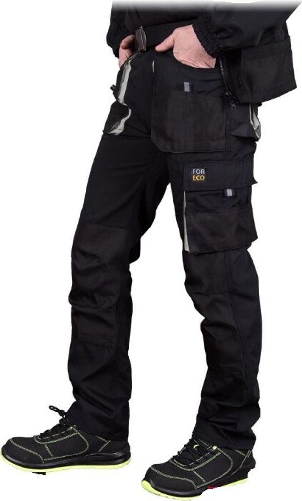 A person wearing black work pants and shoes, shown from the waist down.