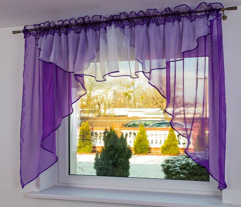 A window with purple and white sheer curtains, showing a snowy outdoor scene with trees and a car.