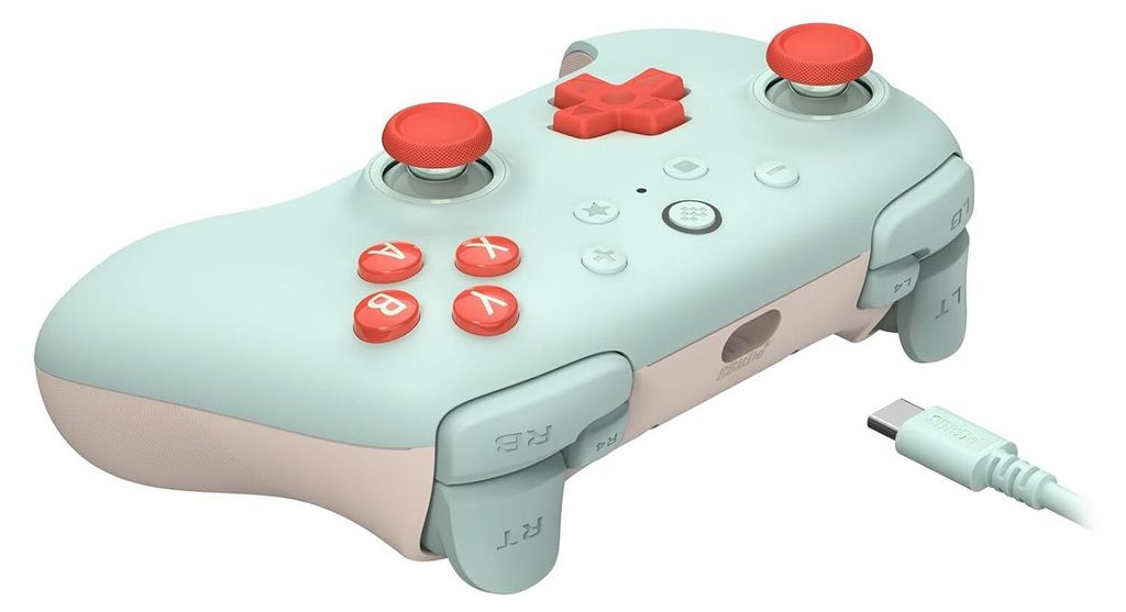 A mint-colored video game controller with red buttons and joysticks, shown with a white USB-C cable.