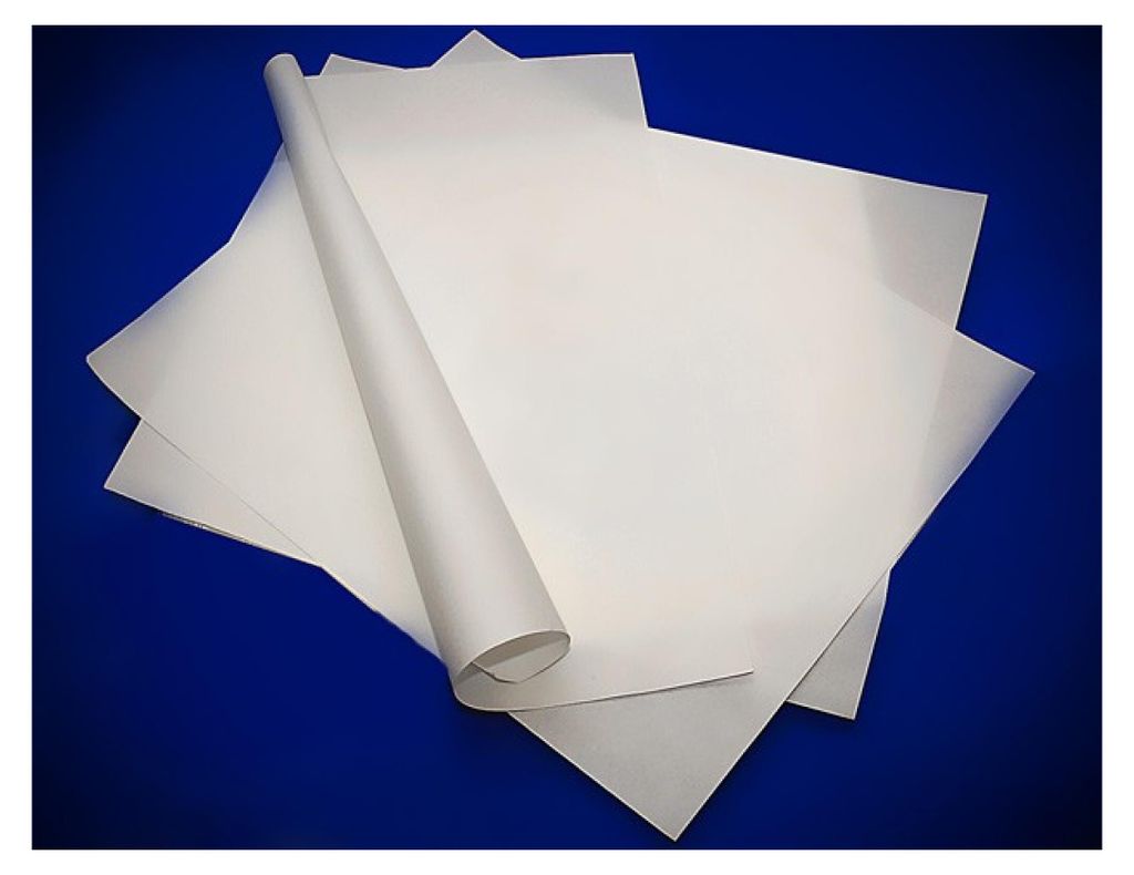 Several sheets of white paper are stacked, with one sheet rolled into a tube.