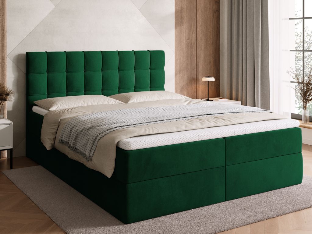 A green upholstered bed with a tufted headboard, set in a bedroom with a window and curtains in the background.