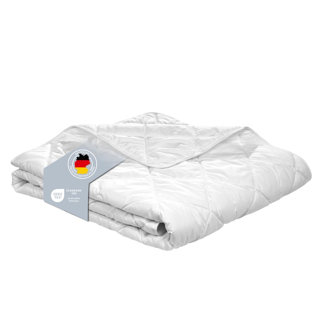 A folded white comforter is presented on a white background, with a label attached to it.