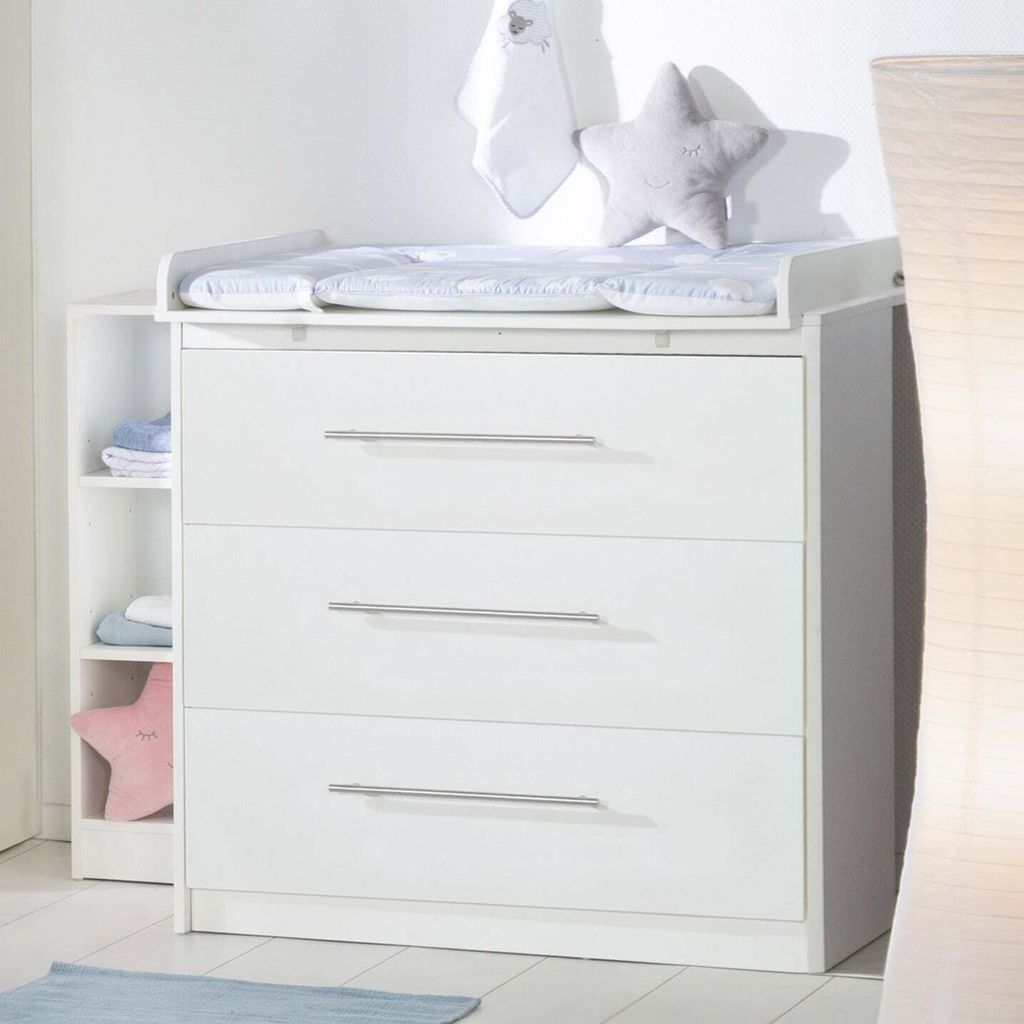 A white baby changing dresser with three drawers and an attached changing pad.