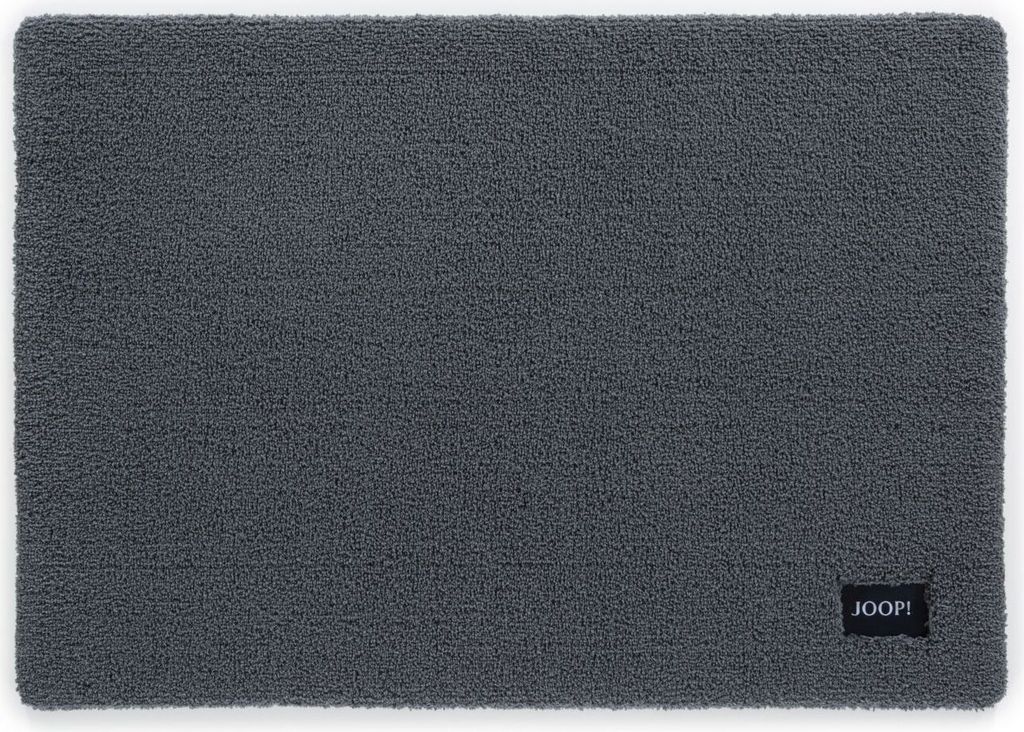 A gray bath mat with a black label in the bottom right corner.