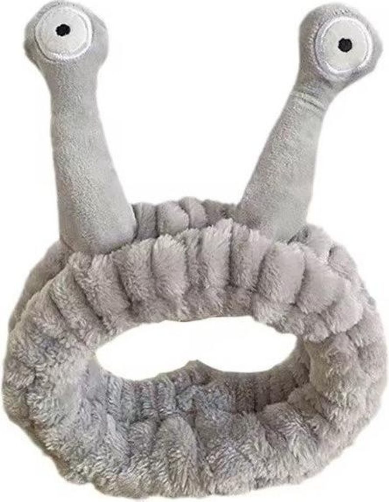 A grey cosmetic headband with two antennae-like protrusions on top, each with an eye design.