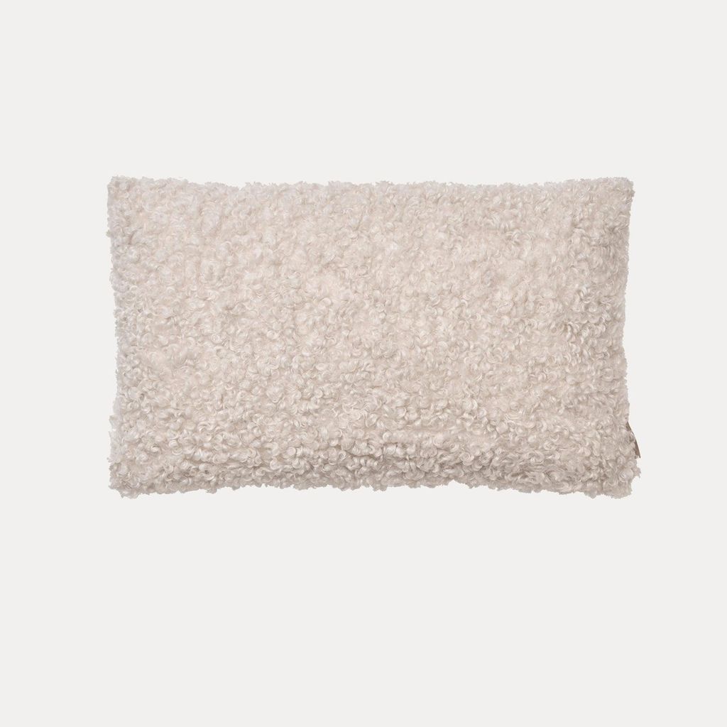 A fluffy, rectangular pillow cover is centered on a light gray background.