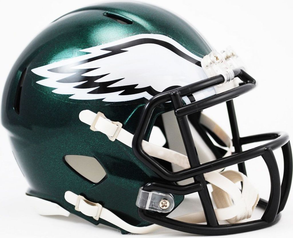 A close-up side view of a green football helmet with a white eagle logo and a black face mask.