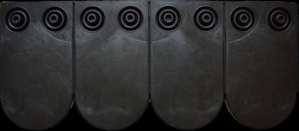 A product shot of four black roofing shingles arranged in a row.