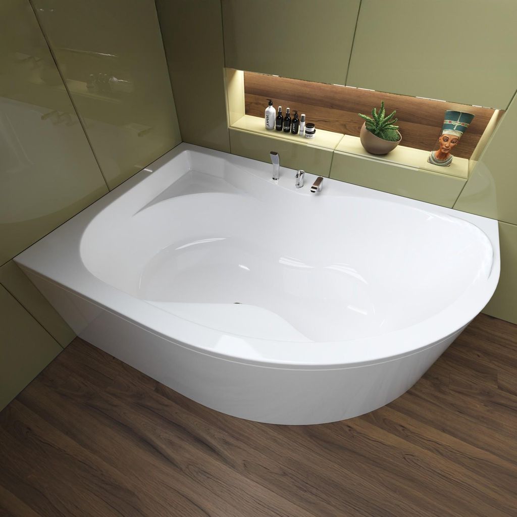 A modern bathroom with a white corner bathtub, green tiled walls, and a wooden floor.