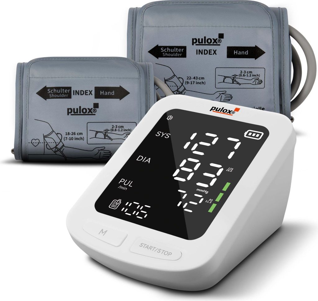 A white digital blood pressure monitor with two gray cuffs is displayed against a white background. The monitor screen shows readings for SYS, DIA, and PUL.