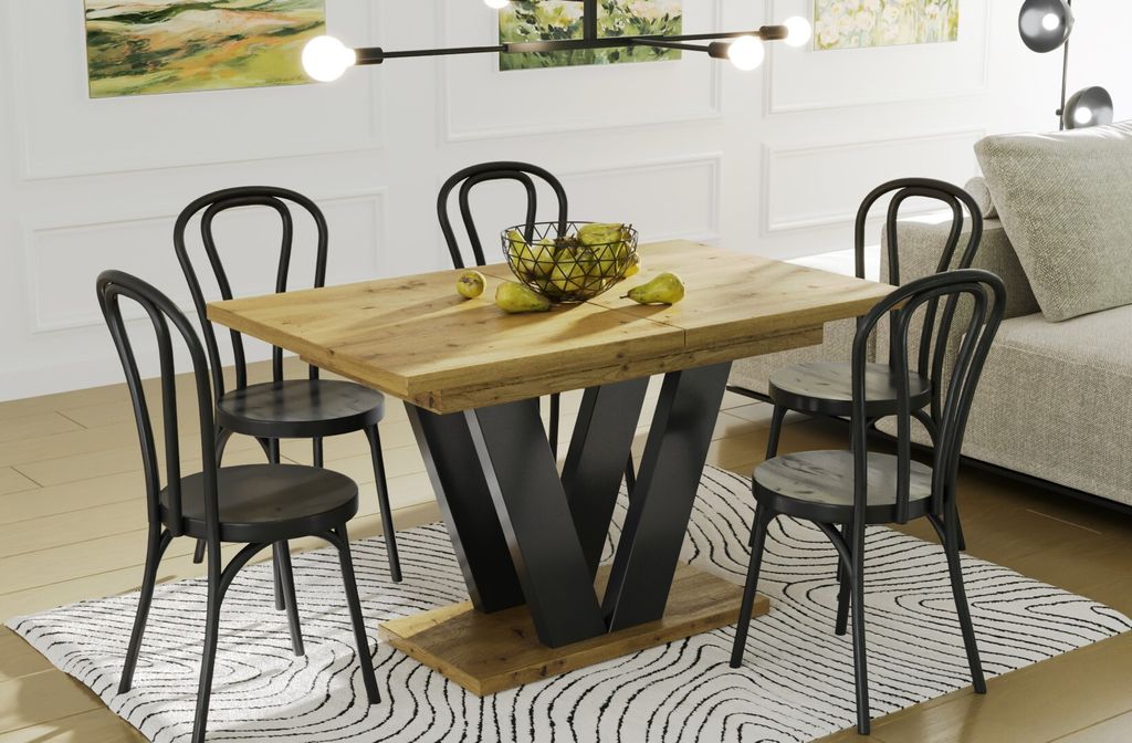 A dining table and chairs set in a well-lit room, with a sofa visible in the background.