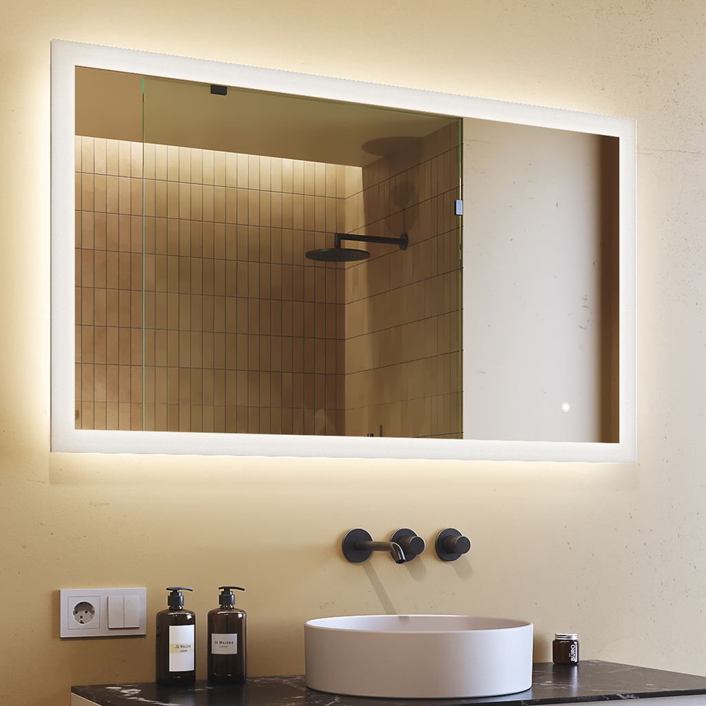 A bathroom vanity with a sink, faucet, and a lit mirror.