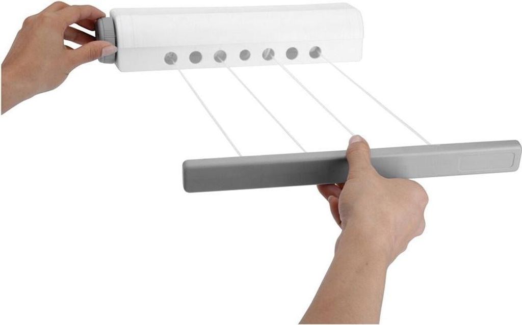 Hands are shown extending and retracting a retractable clothesline from a wall-mounted unit.