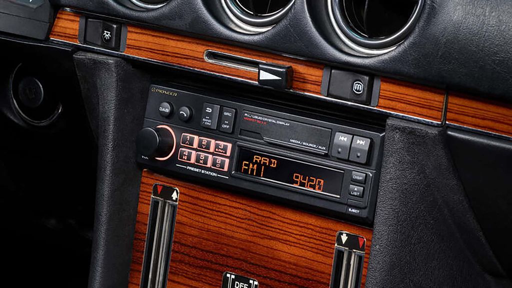 Close-up of a vintage car's dashboard, focusing on the car stereo system.