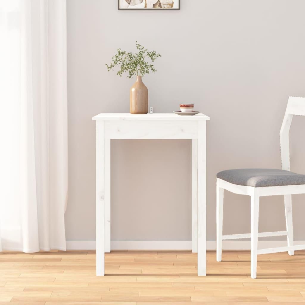 A white wooden dining table with a vase of greenery and a teacup on top, next to a white chair in a room with a white curtain and wooden floor.