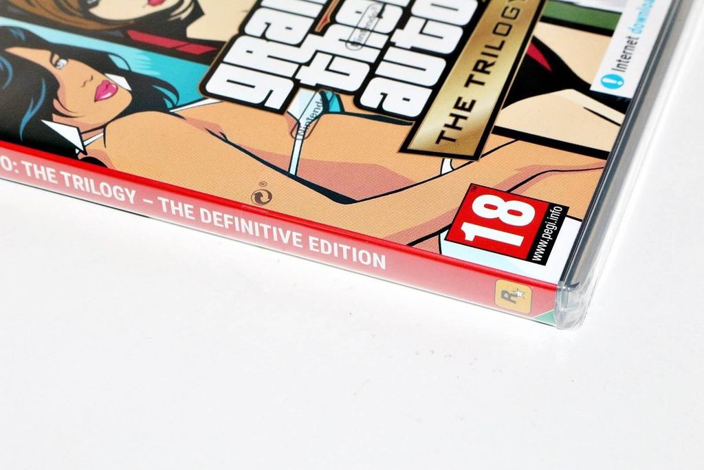 A close-up of the cover art for the Grand Theft Auto: The Trilogy – The Definitive Edition video game, showing stylized characters and the game's title.