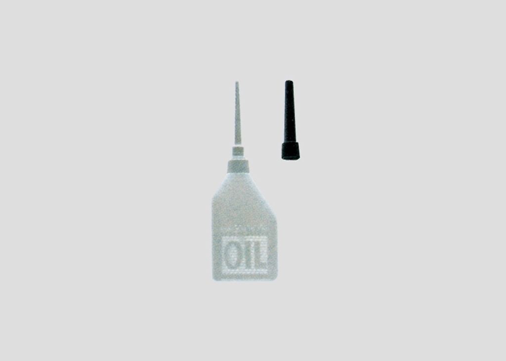 A clear shot of an oil bottle and its cap against a plain background.
