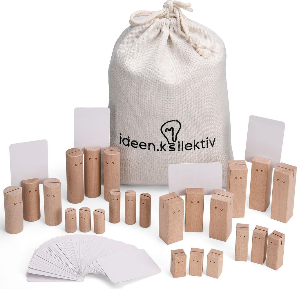 A collection of wooden figures and cards, along with a drawstring bag, are arranged on a white background. The figures are of various sizes and shapes, some resembling stylized people with carved features. The bag has a logo and text printed on it. Several