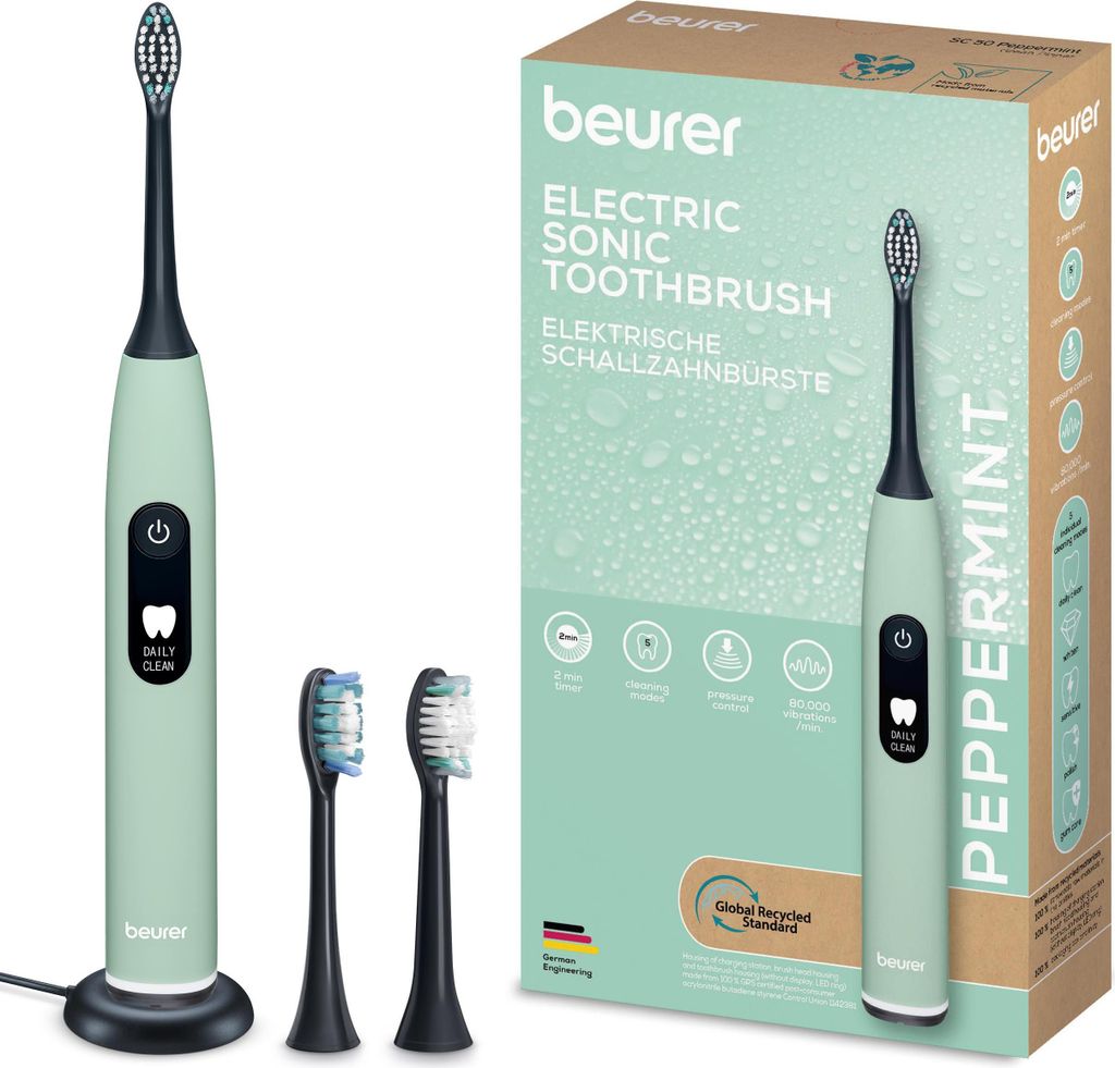 A product shot of a green electric toothbrush and its packaging, along with two extra brush heads.