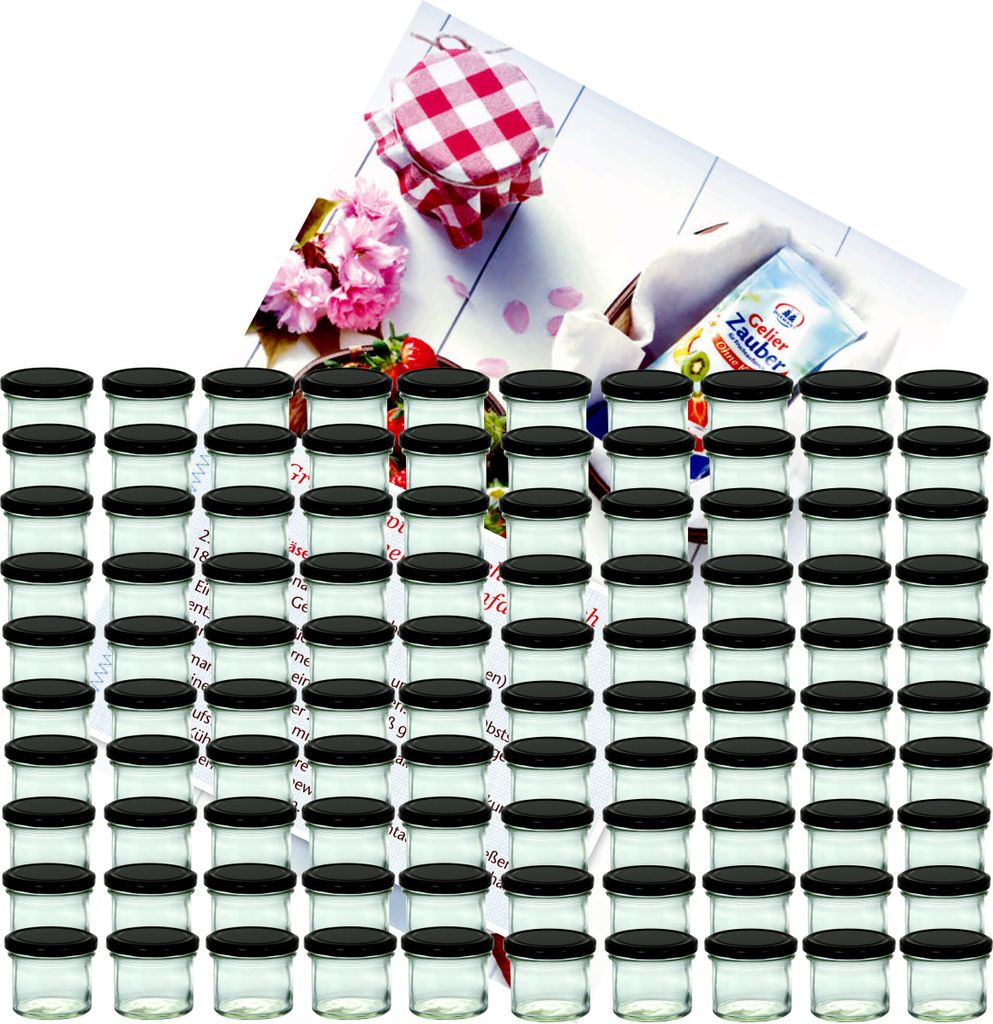 A collection of small glass jars with black lids, arranged in rows, with a decorative card showing flowers and a jar with a red and white checkered lid in the background.
