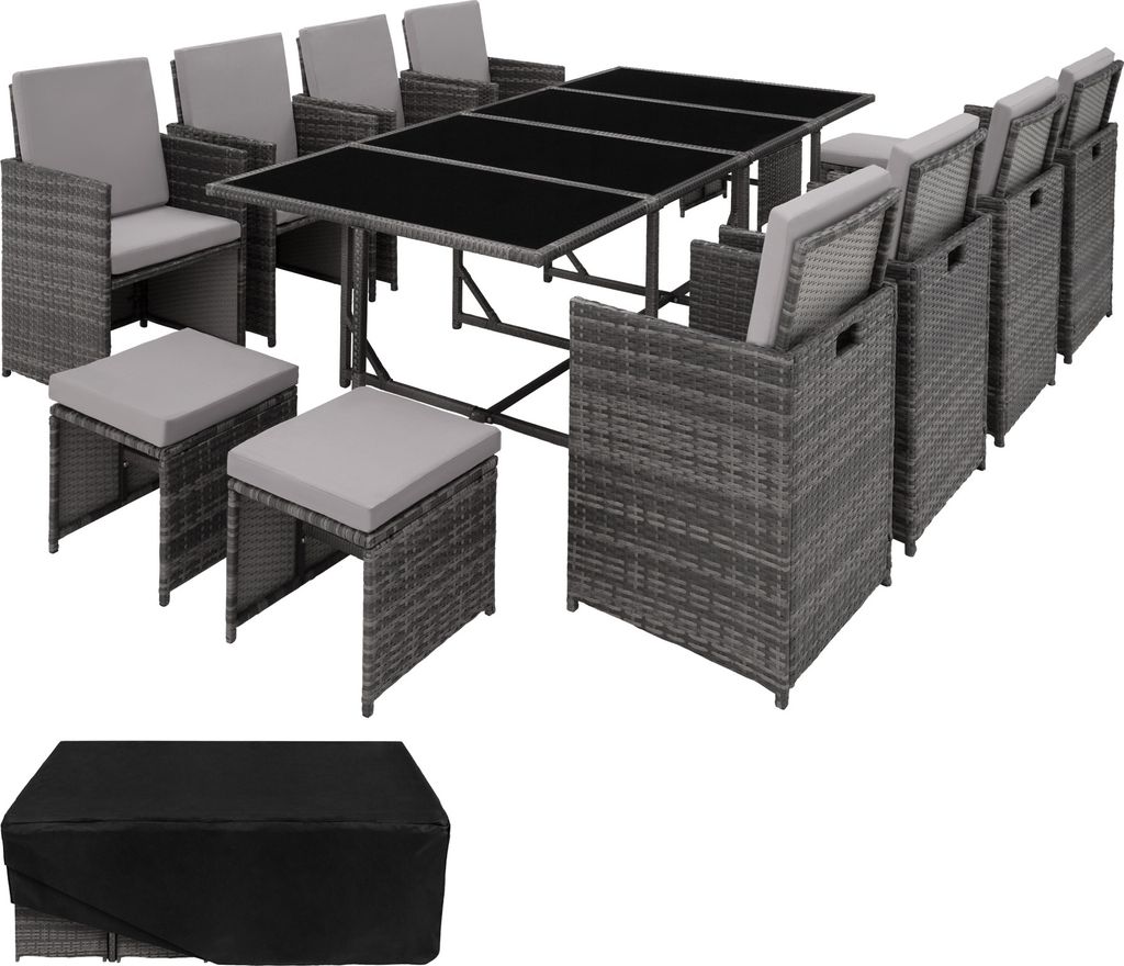 A rattan dining set with chairs, stools, and a table, along with a protective cover.