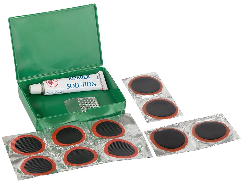 A tire repair kit with patches and glue in a green box.
