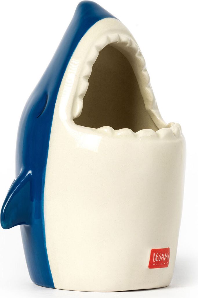 A ceramic pen holder shaped like a shark with its mouth open.