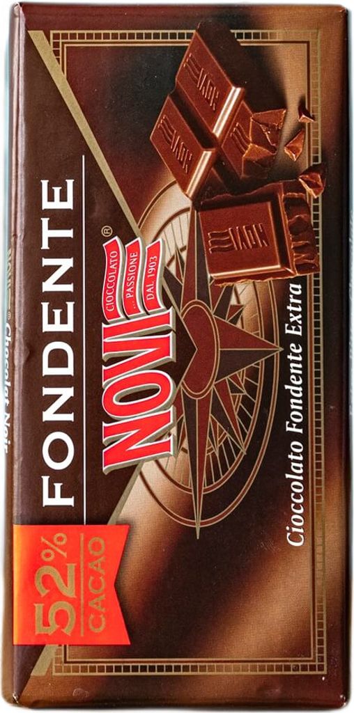 A close-up of a chocolate bar wrapper with a compass design and images of chocolate pieces.