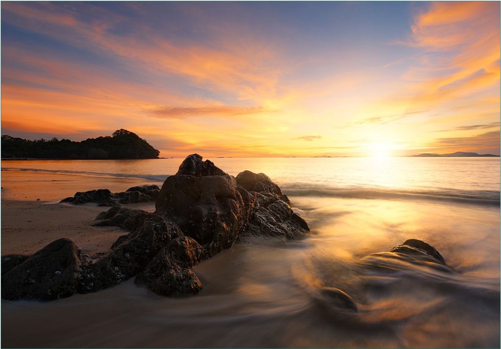 Wallario Fototapete Vliestapete, seidenmatte Oberfläche, einfache Verarbeitung, Größe 300 x 210 cm, Motiv Sonne über dem Meer mit Felsenlandschaft