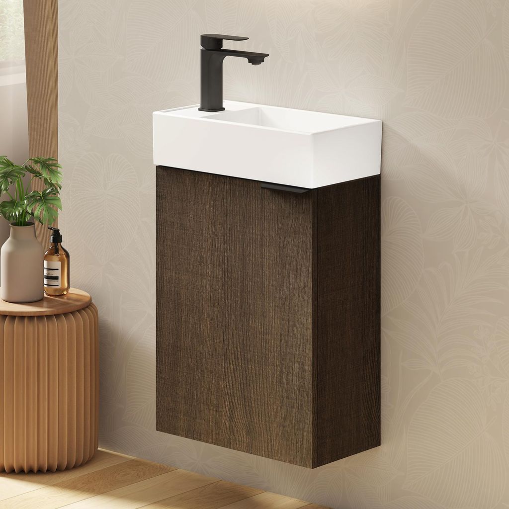 A wall-mounted bathroom vanity with a white ceramic sink and a dark wood cabinet.