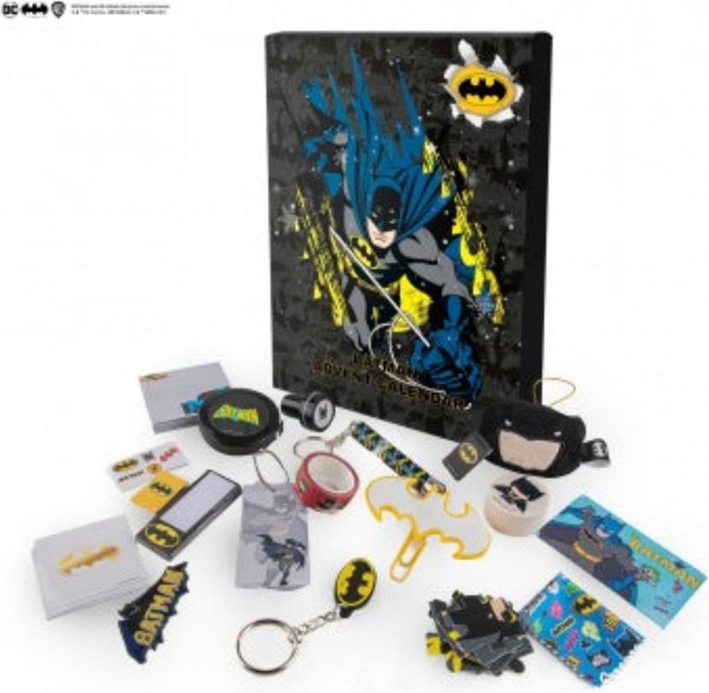 A collection of Batman-themed advent calendar items are spread out on a white surface, with the advent calendar box prominently displayed in the background.