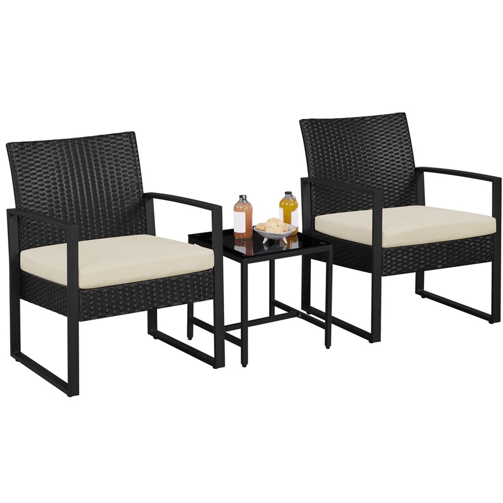 Two black rattan chairs with beige cushions and a small black side table with drinks and snacks, set against a white background.