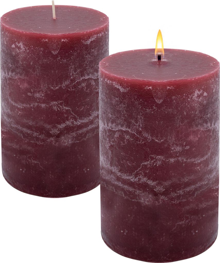 Two burgundy pillar candles on a white background. One candle is lit.