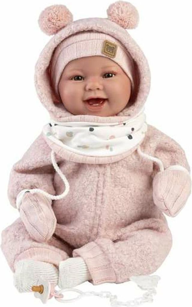A baby doll dressed in a pink outfit, sitting down.