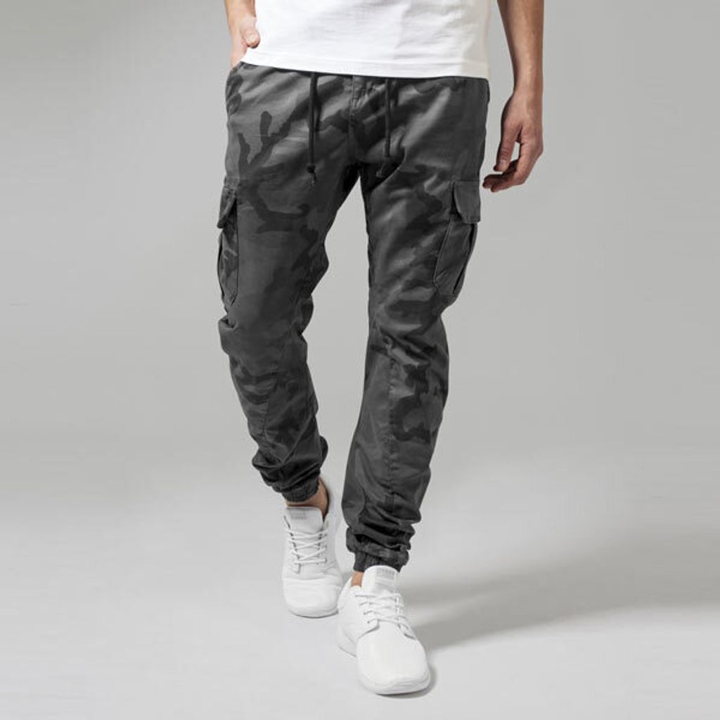 A person is standing and modeling camouflage cargo pants.