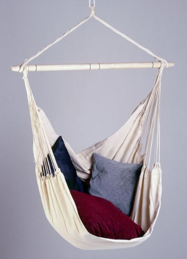 A hammock chair with pillows against a plain background.