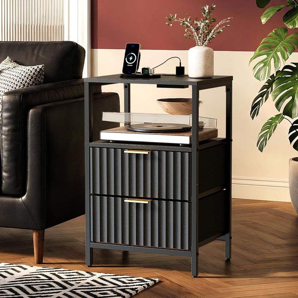 A nightstand with a turntable and drawers, next to a sofa and a plant.