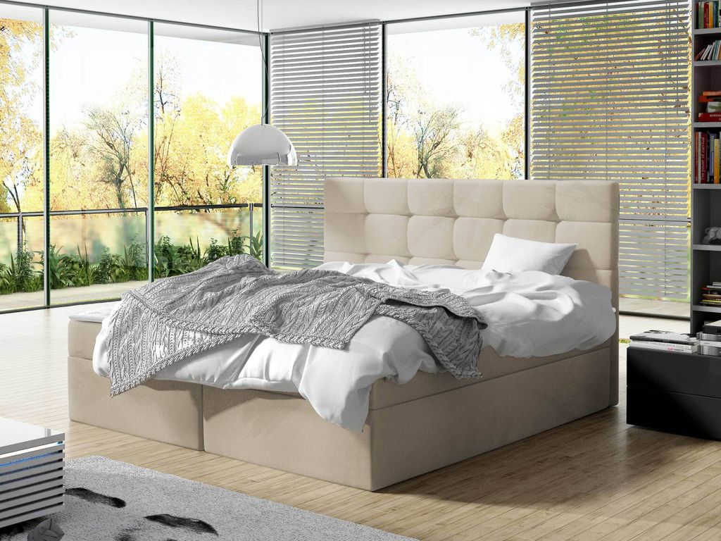 A bedroom with a large bed and a view of trees outside.