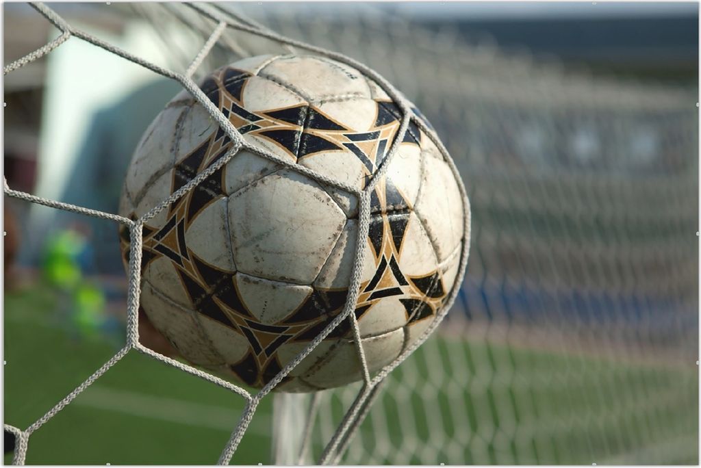 Wallario Wandbild Fußball - Ball im Tor - Bolzplatz, Größe: 61 x 91,5 cm, Poster mit rahmenlosen Bildhalter