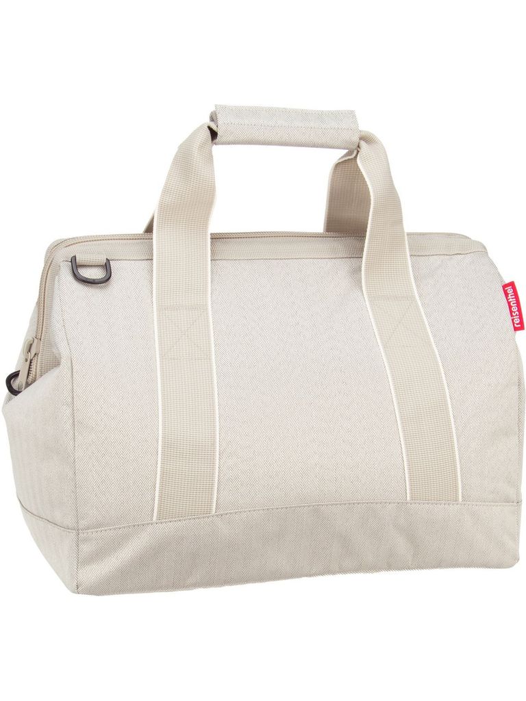 A studio shot of a beige duffel bag against a white background.