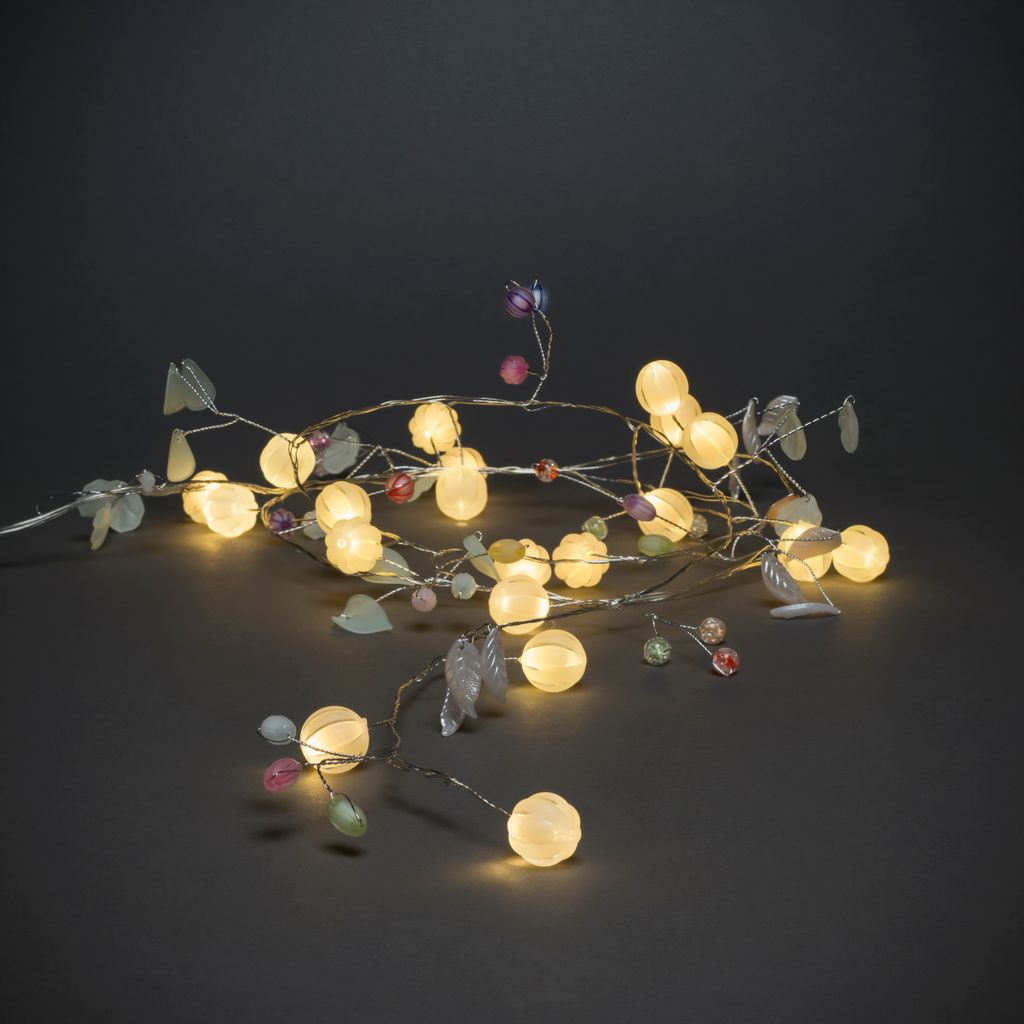 A string of LED lights shaped like branches with leaves and berries.