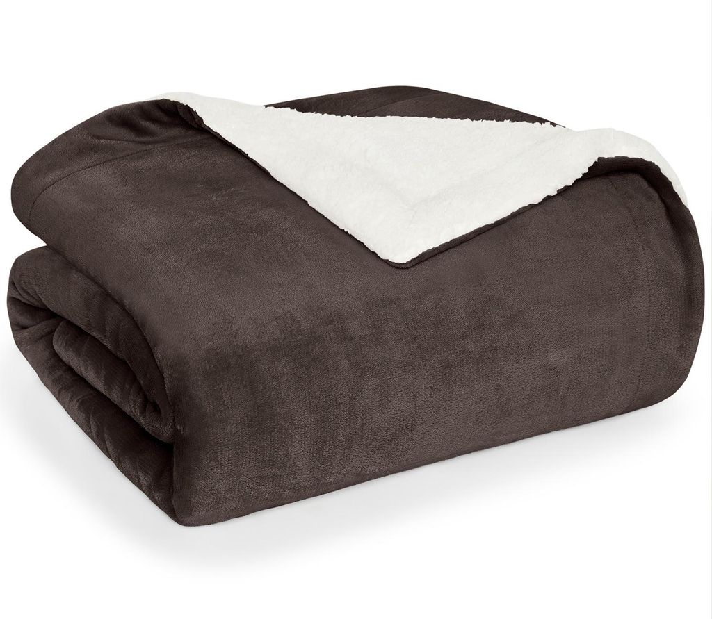 A folded dark brown sherpa blanket with a white lining is shown against a white background.