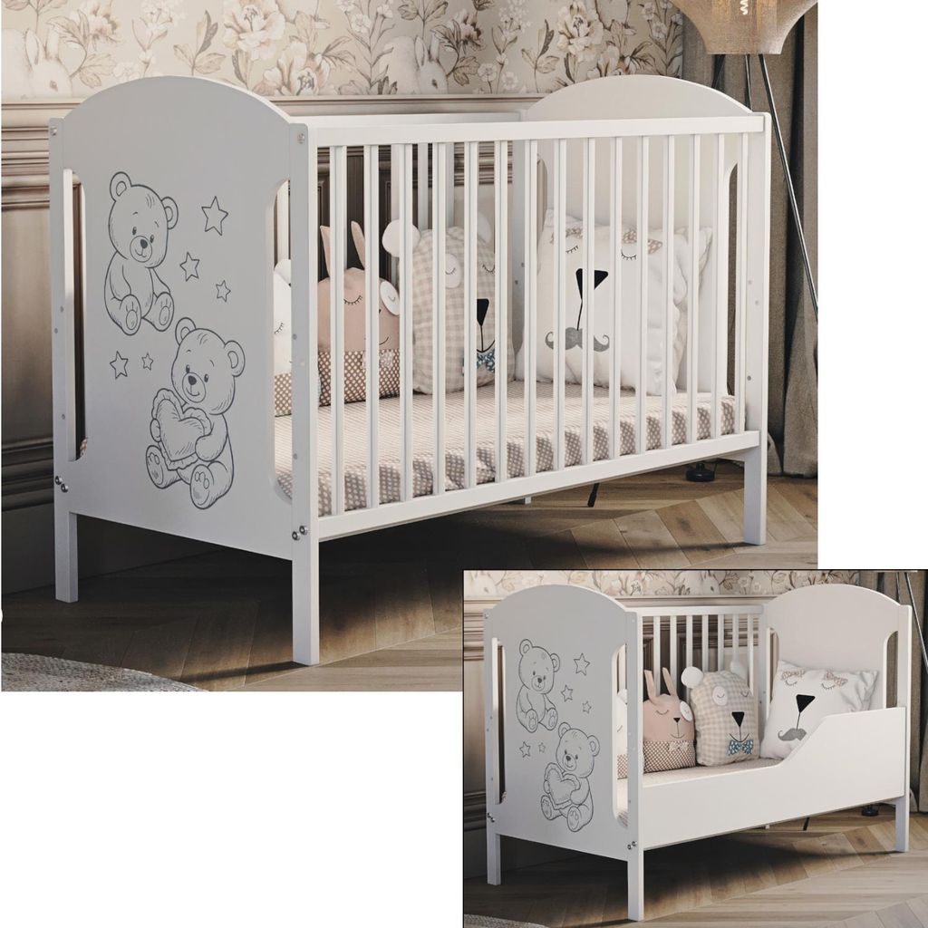 A white wooden baby crib with a teddy bear motif, shown in a room with floral wallpaper.