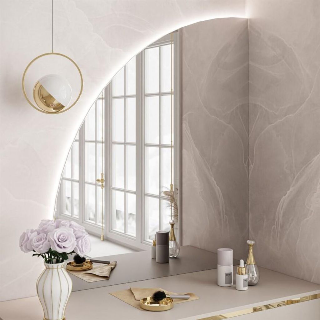 A vanity table with a mirror, flowers, and makeup products.