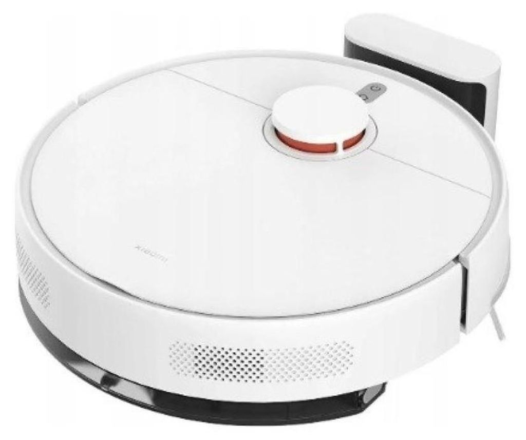 A white robot vacuum cleaner with a charging dock in the background, shown from a slightly elevated angle.
