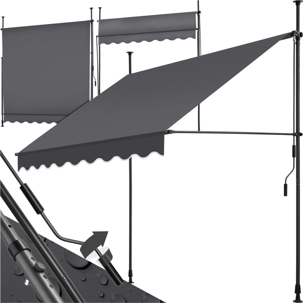 A dark gray retractable awning is shown in a studio setting against a white background. The awning is partially extended, and its frame and crank mechanism are visible. There are also two other awnings in the background, one fully retracted and one partial