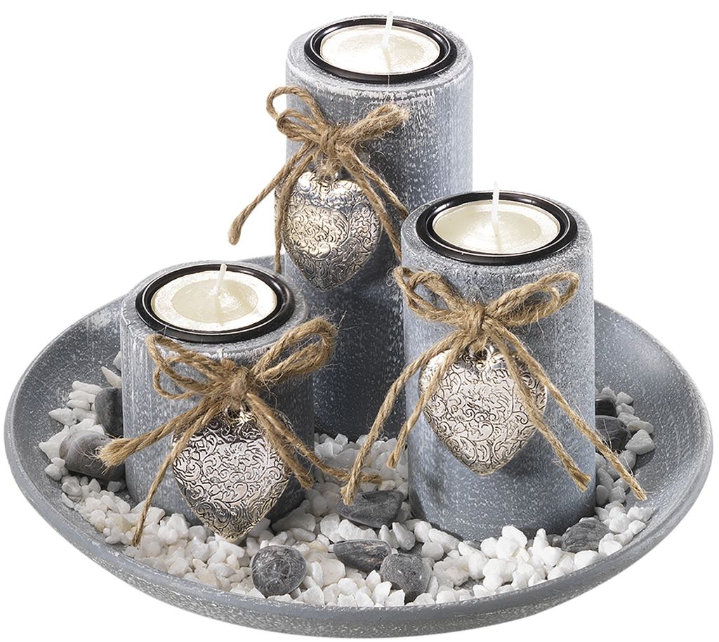A decorative tray with three candle holders, filled with white and gray stones.